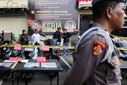 Police officers stand near evidence being displayed at the police station following a shooting incident, in Badung