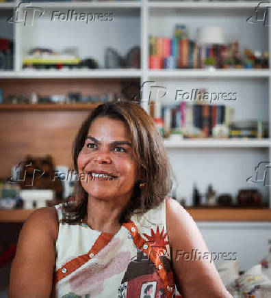 Daniela Falcão posa com obra em casa durante entrevista