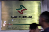 People walk past Hanoi Stock Exchange, in Hanoi