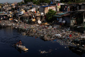 A drone viw shows a man paddling through the polluted Pasig River on World Environment Day in Manila