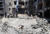 Palestinians search for casualties at the site of an Israeli strike on a house in Gaza City