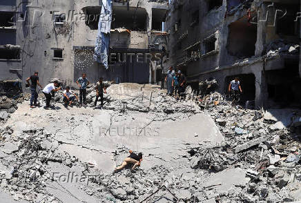 Palestinians search for casualties at the site of an Israeli strike on a house in Gaza City