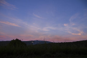Céu azul, com nuvens de nuances alaranjadas, no penúltimo dia do outono