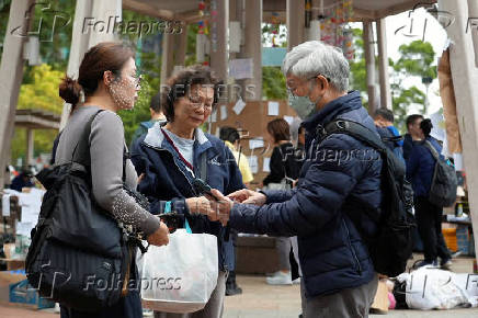 Residents of Wang Fuk Court housing complex gather with their daughter at a nearby park following the deadly fire in Hong Kong