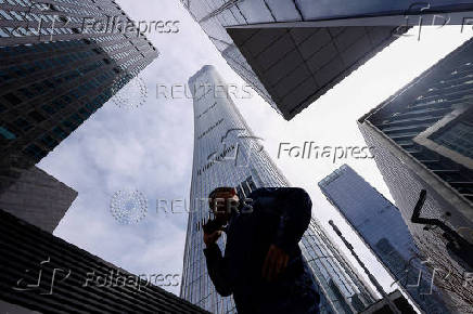 Man walks past buildings at Central Business District (CBD) in Beijing