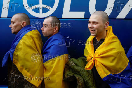 Ukrainian prisoners of war react as they return after a swap in an undisclosed location in Ukraine