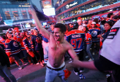 Edmonton Oilers fans react in a fan zone during the first game of the Stanley Cup Finals against the Florida Panthers, in Edmonton