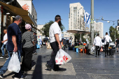 People shop in Jerusalem following an Israeli strike in Iran