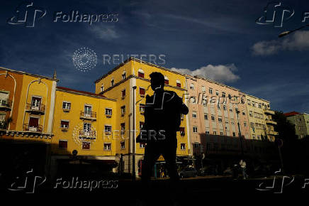 FILE PHOTO: A man walks in silhouette in Lisbon