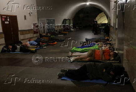 People take shelter inside a metro station during a Russian drone and missile strike in Kyiv