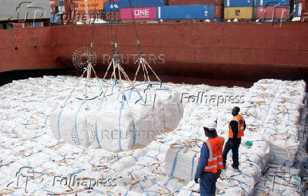Workers unload a shipment of rice from the MV Amira Sophie II, at the Kenya Ports Authority (KPA) container terminal in the port of Mombasa