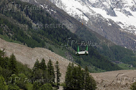 A car is carried by helicopter near Blatten
