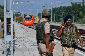 Security force personnel stand guard as India's high-speed train 