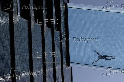 People swim in the Sky Pool during hot weather in London