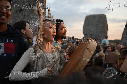 Revellers attend summer solstice celebrations during sunrise at Stonehenge near Amesbury