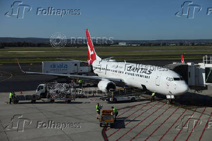 A Qantas aeroplane is unloaded at Adelaide Airport