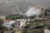 Smoke rises after the Israeli army blew up the house of a Palestinian assailant in Deir Ibzi town, near Ramallah