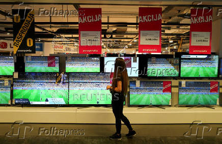 FILE PHOTO: A woman looks at televisions in a store in Zagreb