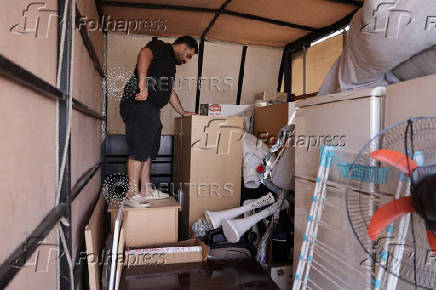 Syrian returnee Ahmed Al-hadid, loads his belongings onto a truck, in Aleppo's countryside