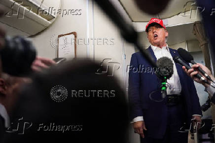 U.S. President Donald Trump speaks to members of the media on board Air Force One on the way to New Jersey