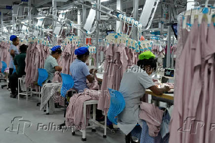 FILE PHOTO: Employees sew garments inside a garment factory in Katunayake on the outskirts of Colombo