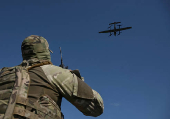 Member of the National Police Special Purpose Battalion looks at an unmanned aerial vehicle during its reconnaissance flight on a front line in Zaporizhzhia Region