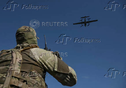 Member of the National Police Special Purpose Battalion looks at an unmanned aerial vehicle during its reconnaissance flight on a front line in Zaporizhzhia Region