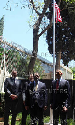 Syrian Foreign Minister Asaad Hassan al-Shibani stands next to U.S. envoy for Syria Thomas Barrack after he raised the American flag at U.S. ambassador's residency in Damascus