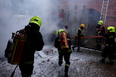 Firefighters extinguish a fire as they participate in a civil defence mock drill inside the premises of an office complex in Srinagar