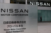 A man stands in front of the global headquarters of Nissan Motor while its annual shareholder meeting is being held in Yokohama