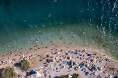 A drone view shows people enjoying the beach during warm weather in Zadar