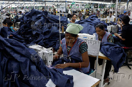Workers stitch denim shirts in a garment manufacturing unit on the outskirts of Ahmedabad