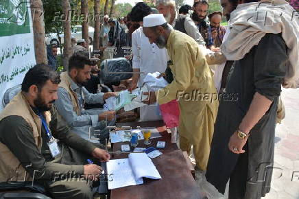 Afghan families, returned from neighboring Pakistan, receive food rations distributed by the Tawheed Charity Foundation in Jalalabad