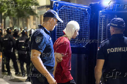 Serbia's police officers detain a demonstrator during standoff between ruling party supporters and anti-government protesters in Belgrade