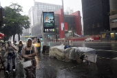 Pedestres enfrentam chuva e queda de temperatura em SP