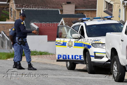 Police officers inspect the scene where kidnapped U.S. pastor, Josh Sullivan, was rescued last night in a shootout during which three suspects were killed, in KwaMagxaki