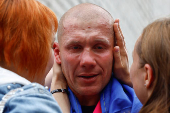 Ukrainian prisoner of war reacts as he embraces his relatives after a swap in an undisclosed location in Ukraine