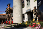 A U.S. Marine and a member of the National Guard stand guard outside the Edward R. Roybal Federal Building, in Los Angeles