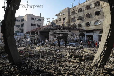 Palestinians inspect destroyed building after Israeli airstrike in Gaza City