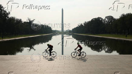 Cyclists pass the reflecting pool in front of the Washington Monument