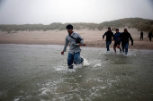 FILE PHOTO: Migrant dinghy heads off the French coast to cross the English channel