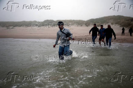 FILE PHOTO: Migrant dinghy heads off the French coast to cross the English channel