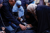 People gather near the bodies of Palestinians killed in Israeli strikes, in Khan Younis