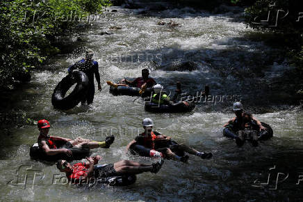 Sports enthusiasts compete while floating on inner tyre tubes during the tyre festival 'Bunar Fest' in Prizren