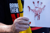 Protestors stand at the entrance to Kibbutz Nir Oz, on the day Israeli PM Netanyahu visits for the first time since the October 7, 2023 attack