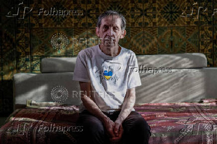 IDP from Enerhodar poses for a photo in his temporary apartment in Zaporizhzhia