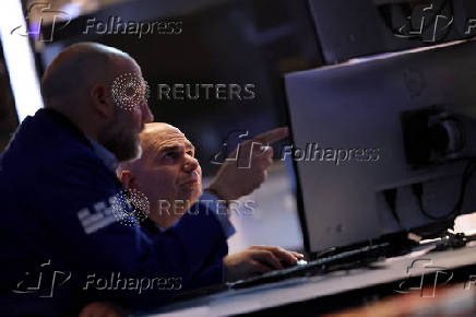 Traders work on the floor at the New York Stock Exchange, in New York City