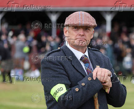 A steward watches a competition during the Braemar Royal Highland Gathering at the Princess Royal and Duke of Fife Memorial Park in Braemar, Scotland