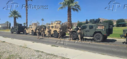 Marines stand near vehicles as they prepare to depart for Los Angeles