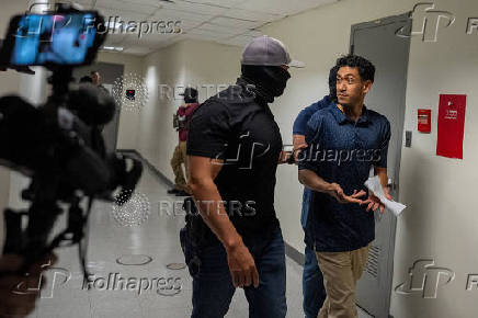 A migrant is detained by federal immigration officers at U.S. immigration court in Manhattan